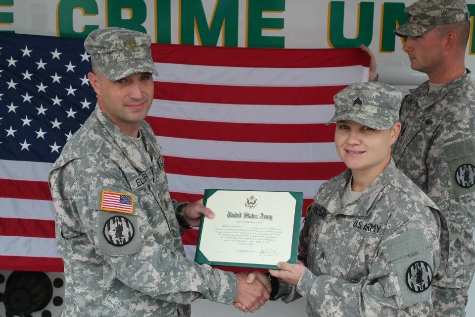 Tania receiving a framed certificate in uniform